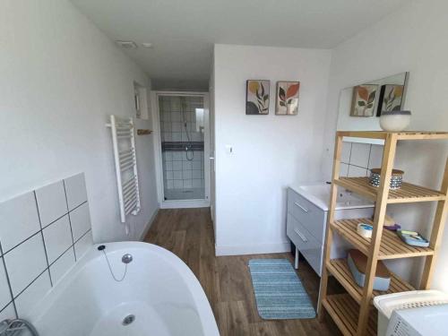 une salle de bains avec une baignoire blanche et un lavabo dans l'établissement Les Malous, à Saint-Quentin-Lamotte-Croix-au-Bailly