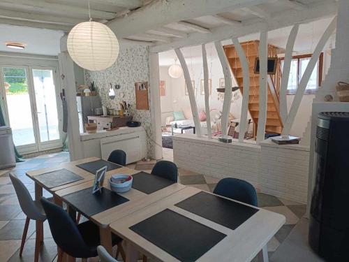 une salle à manger avec une table et des chaises et une cuisine dans l'établissement Les Malous, à Saint-Quentin-Lamotte-Croix-au-Bailly