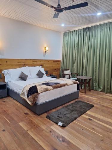 a bedroom with a bed and a ceiling fan at Pines Dirang Homestay in Chug