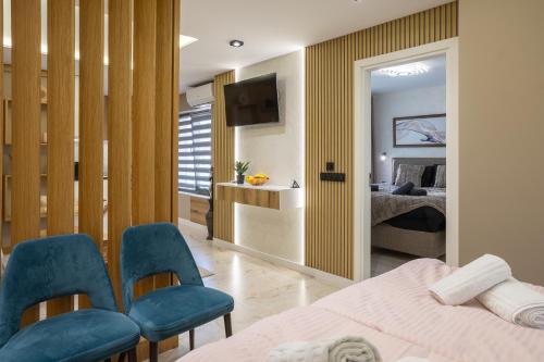 a bedroom with a bed and two blue chairs at Apartments Polejanov in Razlog