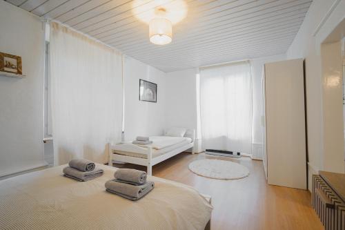 a white room with two beds and a couch at Hostellerie des Princes-Evêques - Le Mystère in Porrentruy