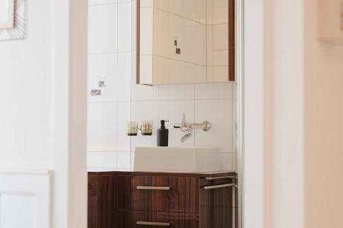 a bathroom with a sink and a cabinet at Hostellerie des Princes-Evêques - Le Mystère in Porrentruy