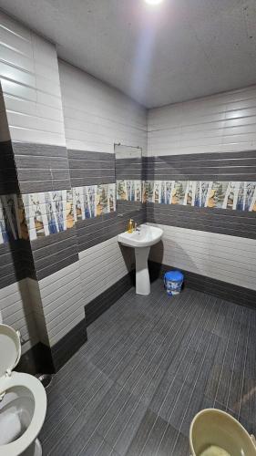 a bathroom with two toilets and a sink at Hotel Jai Palace in Pachmarhī