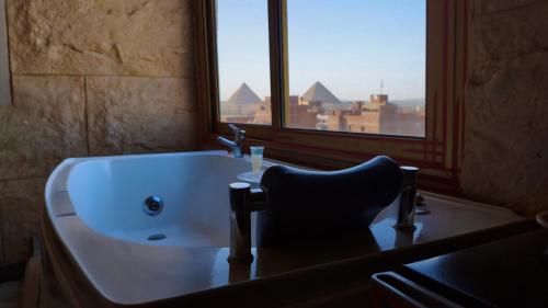 a bathroom with a sink and a chair in front of a window at Pyramids Mystery Inn in Cairo