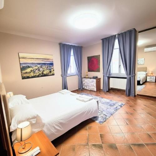 a bedroom with a white bed and two windows at Palazzo Ciravegna, Alba Duomo View in Alba