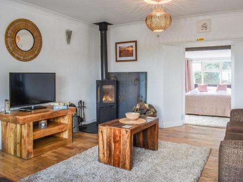 a living room with a tv and a fireplace at The Barn in New Herrington