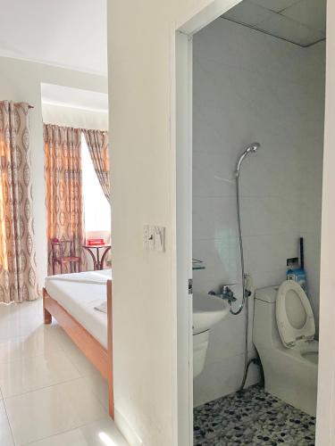 a bathroom with a bed and a toilet and a sink at Nhà Minh Anh in Vung Tau