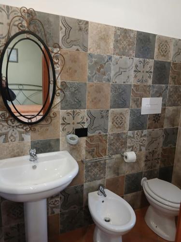 a bathroom with a sink and a mirror and a toilet at Borgo degli Ulivi in Morcone