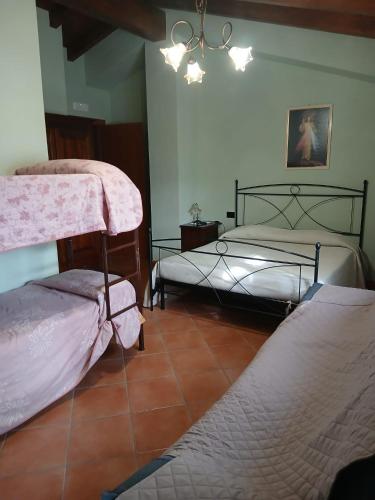 a bedroom with two beds and a chandelier at Borgo degli Ulivi in Morcone