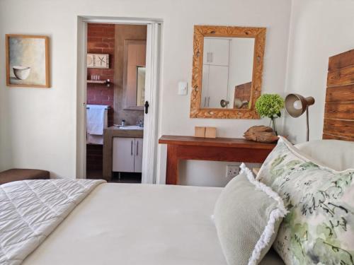 a bedroom with a bed and a mirror and a kitchen at Zu Hause in Piet Retief