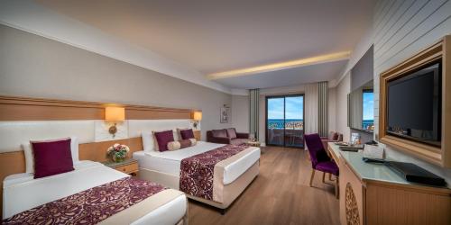 a hotel room with two beds and a flat screen tv at Villa Side Residence in Side