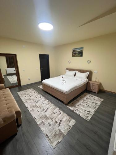 a bedroom with a large bed and two rugs at Apartamentele Liliacul in Sighetu Marmaţiei