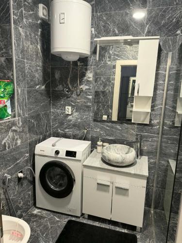 a bathroom with a washing machine and a sink at TriM Apartments in Travnik
