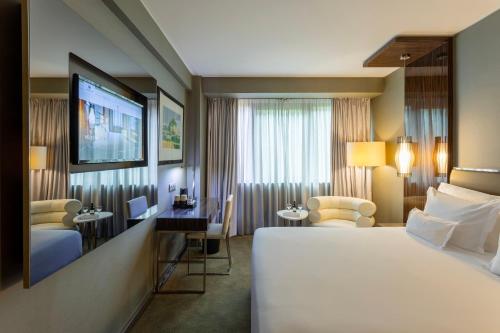 a hotel room with a large bed and a television at Altis Grand Hotel in Lisbon