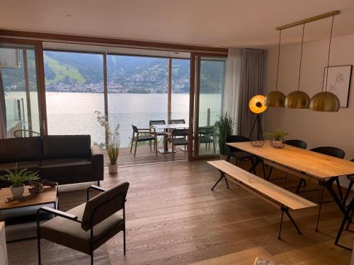 a living room with a table and a view of the water at Bellevue Residences - Luxurious Lakeside Apartments in Zell am See