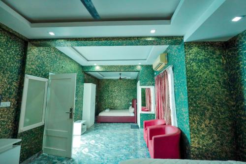 a room with green wallpaper and a bedroom with a bed at Hotel Rieejh in Nāgercoil