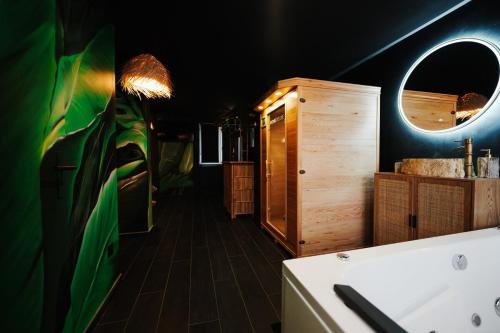 a bathroom with a tub and a sink and a mirror at Jungle Room Dunkerque centre in Dunkerque