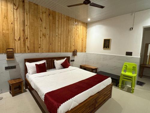 a bedroom with a bed and a green stool at The Lazymojo in Tāla