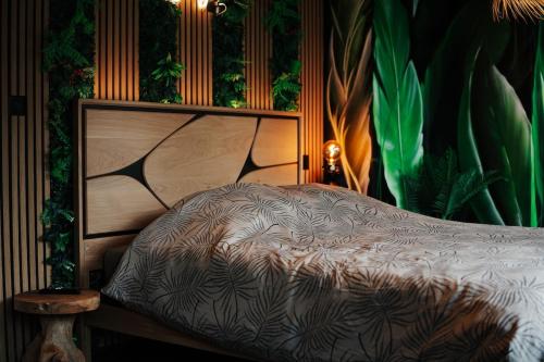 a bedroom with a bed with plants on the wall at Jungle Room Dunkerque centre in Dunkerque