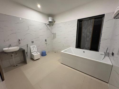 a bathroom with a tub and a sink and a toilet at The Lazymojo in Tāla