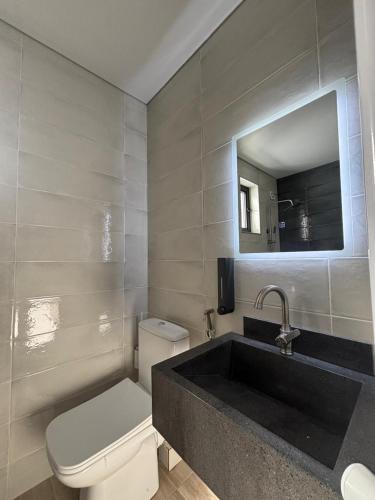 a bathroom with a sink and a toilet and a mirror at Guesthouse Laurbili in Mestia