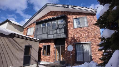 a brick house with a black roof at 9Stay函館 in Hakodate
