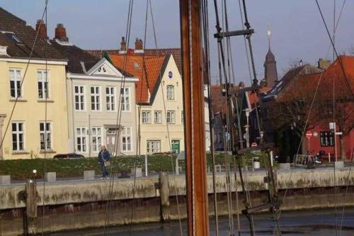 a boat in the water next to some buildings at Am Hafen 13 in Glückstadt