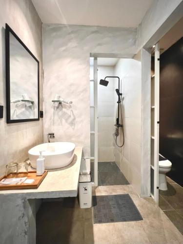 a bathroom with a sink and a shower and a toilet at d'primahotel Yogyakarta in Yogyakarta