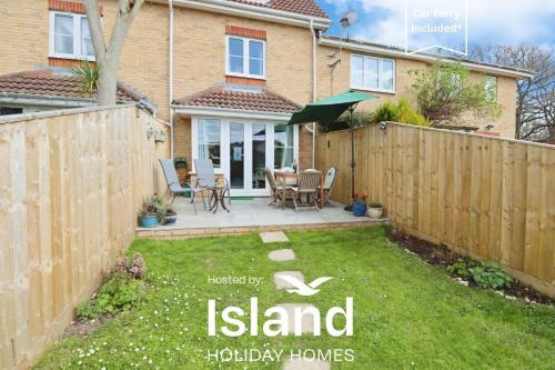 a backyard with a wooden fence and a table and chairs at 28 Anchorage Way in East Cowes