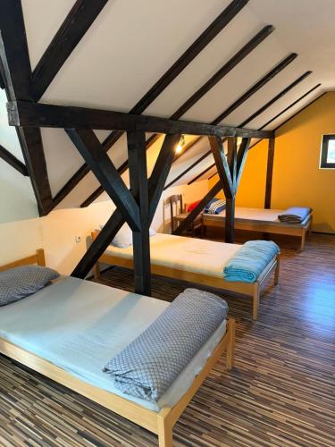 ein Zimmer mit drei Betten in einem Zimmer in der Unterkunft Pecinci Hostel in Pećinci