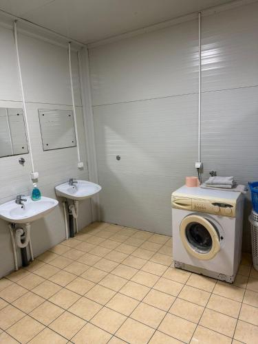 ein Waschraum mit Waschmaschine und zwei Waschbecken in der Unterkunft Pecinci Hostel in Pećinci