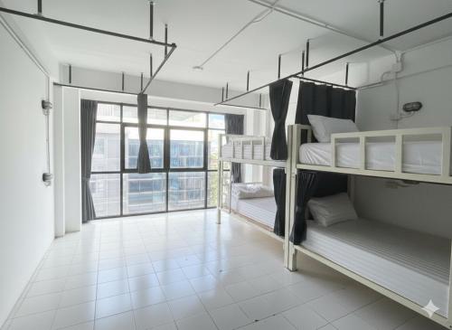 a room with three bunk beds with a large window at Rainbow hostel Chiang mai in Chiang Mai