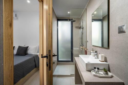 a bathroom with a sink and a bed and a mirror at Villa Salty Sun 7 in Kremasti