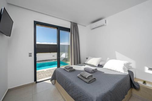 a bedroom with a bed and a view of a pool at Villa Salty Sun 7 in Kremasti