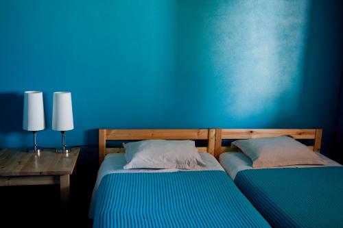 two beds in a room with a blue wall at Ecoland Casa de Campo in Mértola