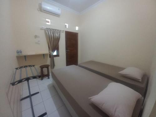 a room with two beds and a chair in it at Niti Guest House in Tegalan