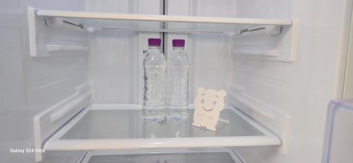 zwei Flaschen Wasser in einem leeren Kühlschrank in der Unterkunft Gate 303 in Seoul
