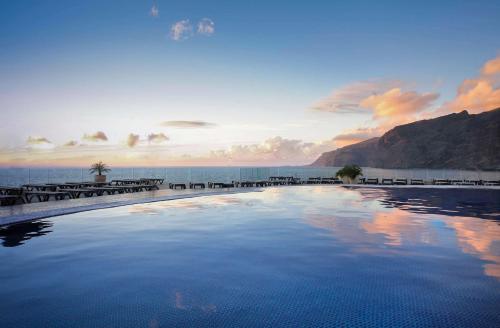 a swimming pool with the ocean in the background at Barceló Santiago - Adults Only in Puerto de Santiago