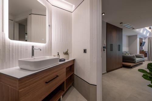 ein Badezimmer mit Waschbecken und Spiegel in der Unterkunft CENTRO Suites in Kalamata