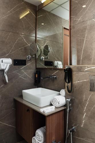 a bathroom with a sink and a mirror at Hotel Park Royal in Dwarka