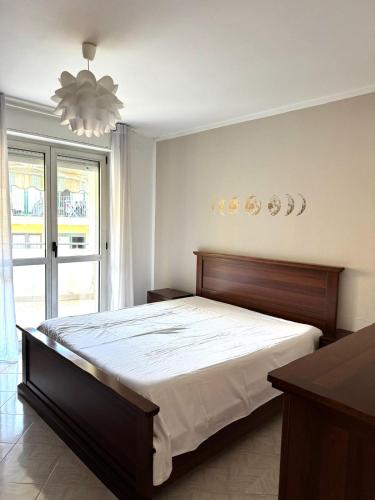 a bedroom with a large bed and a chandelier at Appartamento Trieste Airport in Ronchi dei Legionari