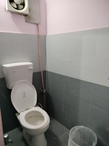 a bathroom with a toilet and a trash can at Hotel Padamaa Palace in Varanasi