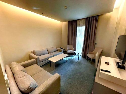 a living room with a couch and a tv at Rawsheh Boutique Hotel in Beirut