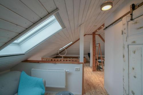 a attic room with a skylight and a couch at Mor Mor Hus in Böhl