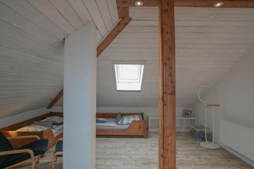 a attic bedroom with a bed and a window at Mor Mor Hus in Böhl