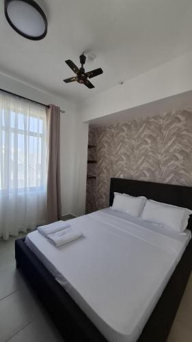 a bedroom with a bed with a ceiling fan at Bahari Home in Nyali