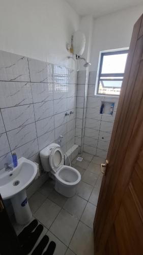 a bathroom with a toilet and a sink at Bahari Home in Nyali