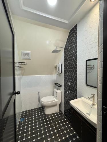 a bathroom with a toilet and a sink at D'Anjung Cottage Paka in Paka