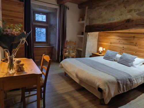 a bedroom with a large bed and a table and a table sidx sidx at Chambres d'hôtes Les Violles in Chirac