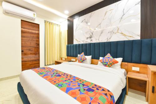 ein Schlafzimmer mit einem großen Bett mit blauem Kopfteil in der Unterkunft FabHotel D3 - Vaishali Nagar in Jaipur